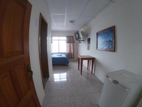 a hallway of a room with a toilet and a table at Grand Hotel Paraiso Insular 1 in Puerto Baquerizo Moreno