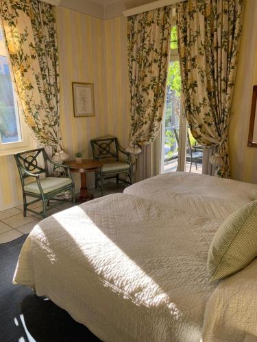a bedroom with a bed and chairs and a window at Ristorante della Stazione da YanElo in Intragna
