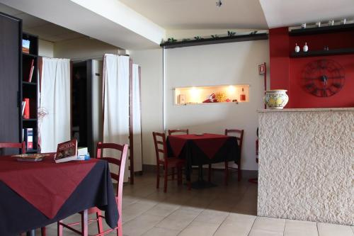 a dining room with tables and chairs and a clock on the wall at i Santuzzi in Lentini