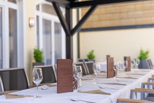 a row of tables with wine glasses and napkins at City Hotel Stockerau in Stockerau