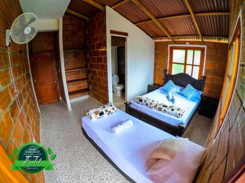 a room with two beds and a fan in it at Finca Hotel Betel in San Carlos
