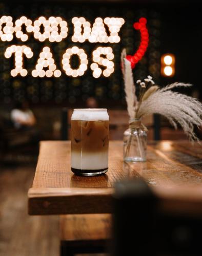a drink sitting on a wooden table with a vase at Taos Valley Lodge in Taos