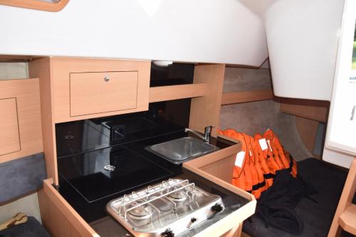 a small kitchen with a stove and a sink at Phobos 24,5 Yacht in Polańczyk