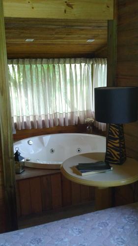 bañera junto a una ventana con lámpara en Pousada Natureza Serrana, en Urubici