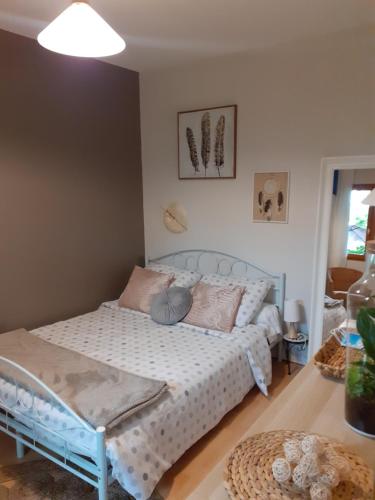 a bedroom with a bed with a white bedspread at Au Bosquet, chambre et salle de bains avec petit déjeuner à 600 m du centre dans un cadre calme et verdoyant in Salies-de-Béarn