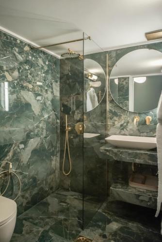 a bathroom with a shower with a sink and a mirror at Luxury Premium Suite #5 in Chalkida