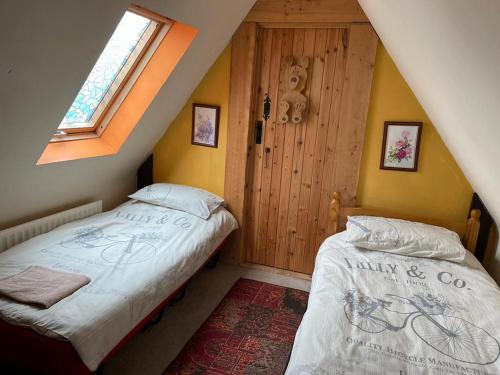 2 camas individuais num quarto com um sótão em Yarm cottages sleeping 12 em Kirk Leavington