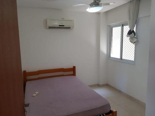 Un dormitorio pequeño con una cama y una ventana. en Jockey Family Chamonix 3, en Vila Velha