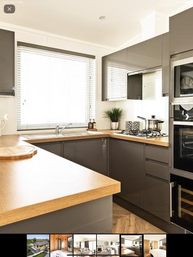 a kitchen with gray cabinets and a large window at Cairn Lodge in Woodhall Spa