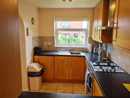 a small kitchen with a sink and a window at Immaculate 3-Bed House with free parking in Bolton in Bolton