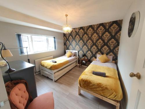 um pequeno quarto com 2 camas e uma janela em Luxury Victorian Home Slough, Legoland, Windsor em Slough