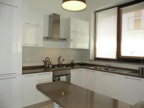 カンネートにあるAppartamenti Holiday Housing Canneto Lipariの白いキャビネットとシンク付きのキッチン
