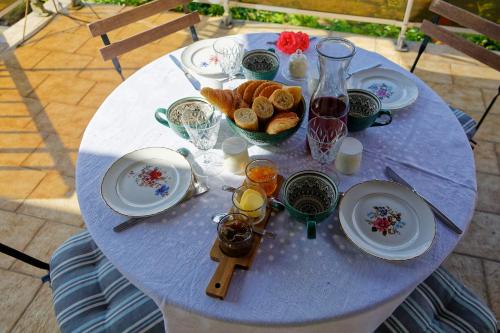 uma mesa azul com pratos e comida em Les Chambres de la Vallée em Argenton-Château