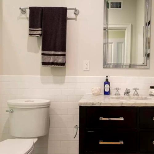 a bathroom with a toilet and a sink and a mirror at Spectacular vacation home with excellent location in New York in New York