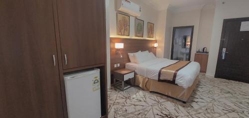 a hotel room with a bed and a refrigerator at فندق ربوة الصفوة 8 - Rabwah Al Safwa Hotel 8 in Al Madinah