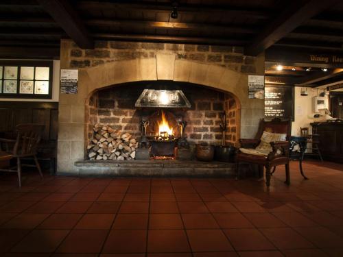 a large brick fireplace with a fire in it at Wellington Inn in Harrogate