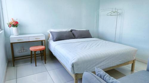 a small bedroom with a bed and a stool at No.16 The Nordic @ Opposite Puchong IOI Mall in Puchong