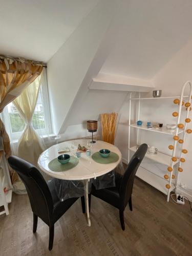 une salle à manger avec une table et des chaises dans l'établissement Le cocon jaune - Studio en hyper centre, à Lamballe