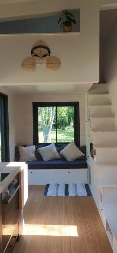 - un salon avec un canapé et une fenêtre dans l'établissement Tiny house chez Caroline, à Gaillan-en-Médoc