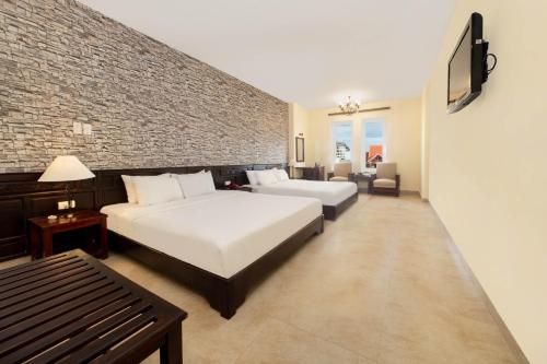 Postel nebo postele na pokoji v ubytování Gold Coast Da Nang Hotel