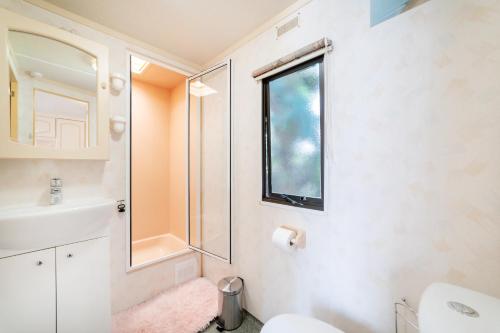 łazienka z umywalką, toaletą i oknem w obiekcie Domek 112 w Jastarni
