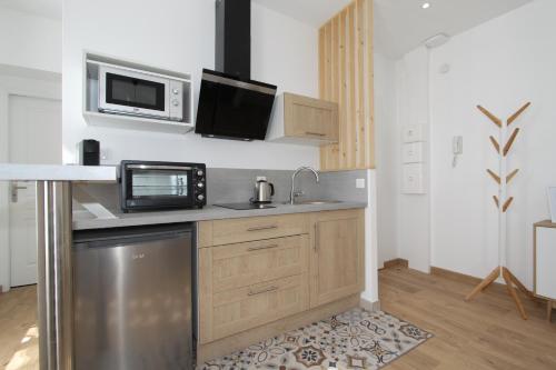 a kitchen with a sink and a microwave at Le Zen by EasyEscale in Romilly-sur-Seine