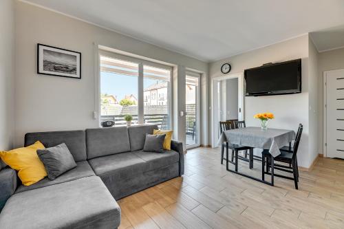 a living room with a couch and a table at APARTAMENTY PIAMOLA Willa Zacisze Kąty Rybackie in Kąty Rybackie