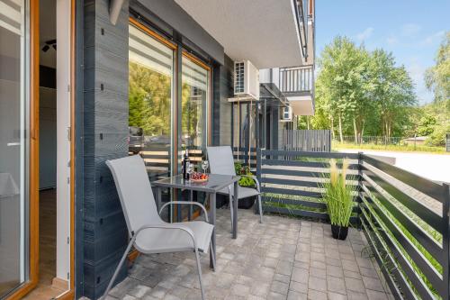 a patio with a table and chairs on a balcony at APARTAMENTY PIAMOLA Willa Zacisze Kąty Rybackie in Kąty Rybackie