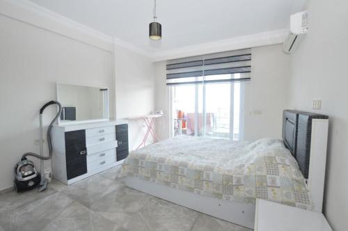 um quarto com uma cama, uma cómoda e um espelho em Apartment 1+1 in ANOTHER WORLD Complex em Alanya