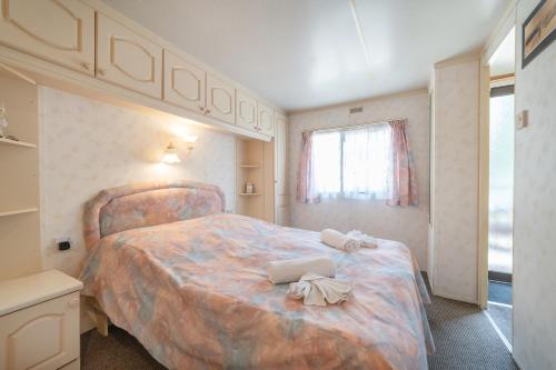 ein Schlafzimmer mit einem großen Bett und einem Fenster in der Unterkunft Domek 112 in Jastarnia