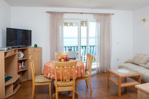 a living room with a table and chairs and a couch at Apartments Waterfront IVAN 2 in Podgora