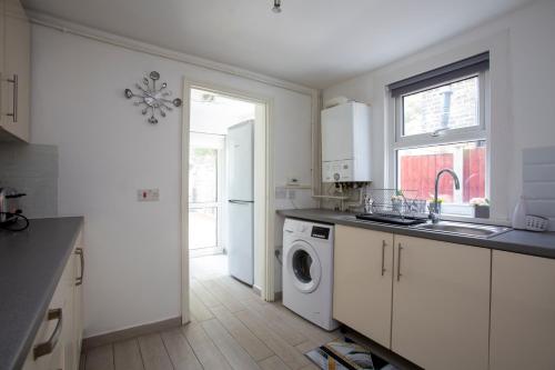 a kitchen with a sink and a washing machine at Dream Home Near Stratford Olympic Park London in London