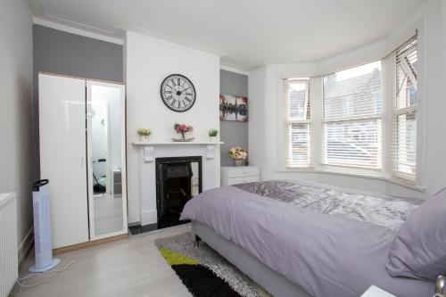 - une chambre avec un lit et une horloge murale dans l'établissement Dream Home Estate, à Londres