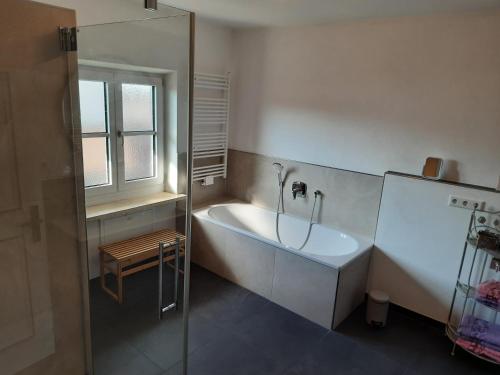 baño con bañera, lavabo y ventana en Ferienwohnung Fenzl, en Rimsting