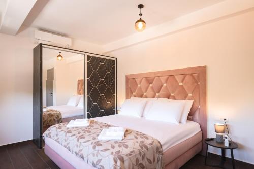 Un dormitorio con una cama grande y un espejo. en Rhapsody in Green - Luxury villa in Zadar, en Crno