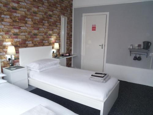 a bedroom with two beds and a brick wall at The Sefton Blackpool in Blackpool