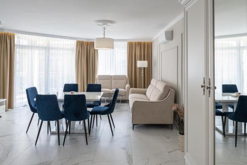a living room with a table and chairs and a couch at Apartamenty Prestige Mielno-Uniescie in Unieście
