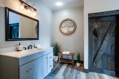 ein Badezimmer mit Waschbecken und Spiegel in der Unterkunft Pine Cove Cabin - Hot Tub, Game Room, Theater Room in Pigeon Forge