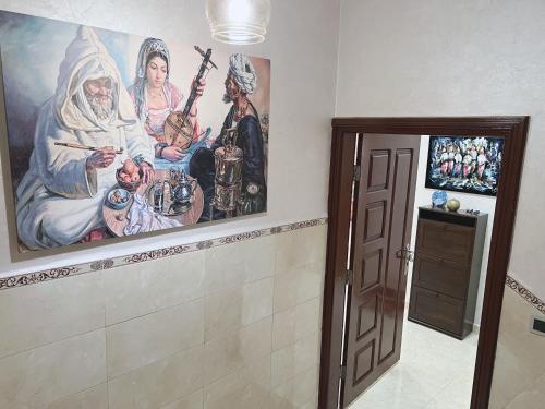 a room with a painting on the wall and a door at Au dix sept in Dakhla