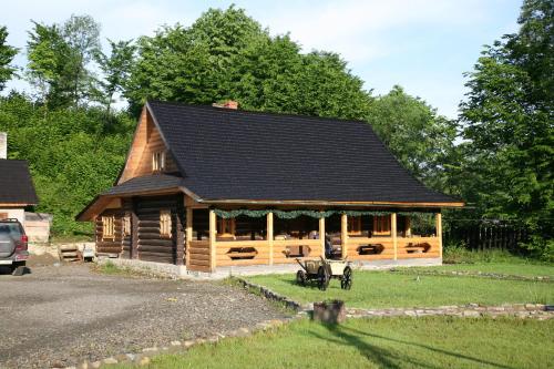 a large wooden cabin with a black roof at Stara Khata Карпати in Sheshory