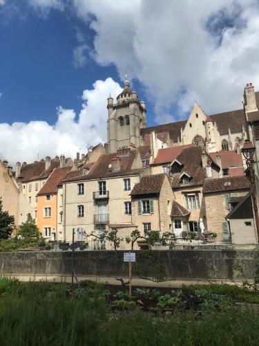 un bâtiment avec une tour au sommet d'une ville dans l'établissement Appartement près de DOLE, à Menotey