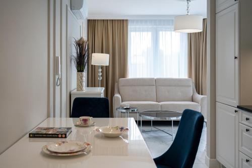 sala de estar con mesa y sofá en Apartamenty Prestige Mielno-Uniescie, en Unieście