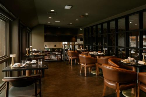 a restaurant with tables and chairs and a bar at Mount Royal Hotel in Banff