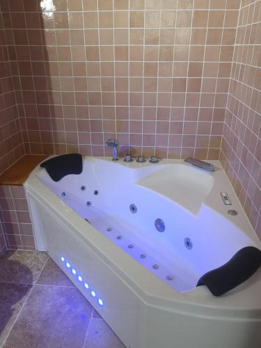 La salle de bains carrelée est pourvue d'une baignoire blanche. dans l'établissement Le Petit Astro parking privé, à Turckheim