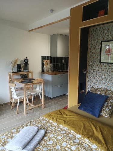 une chambre avec un lit et une table et une cuisine dans l'établissement Le Petit Astro parking privé, à Turckheim