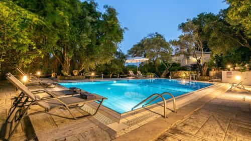 a swimming pool with two lounge chairs next to it at Villa Scheria in Benitses