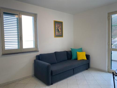 a blue couch in a living room with two windows at CannetoMare in Canneto