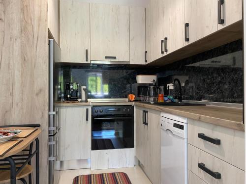a kitchen with white cabinets and a counter top at New Apartment in the City in Visoko