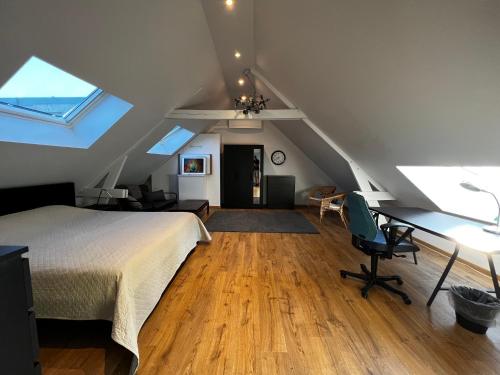 a bedroom with a bed and a desk in a attic at B&B Den Engel in Kortenberg