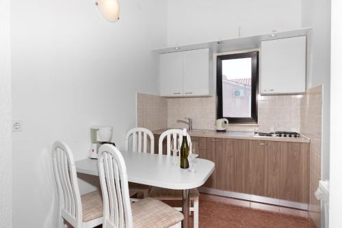 una cucina con tavolo e sedie bianchi di Villa Paradiso a Punat